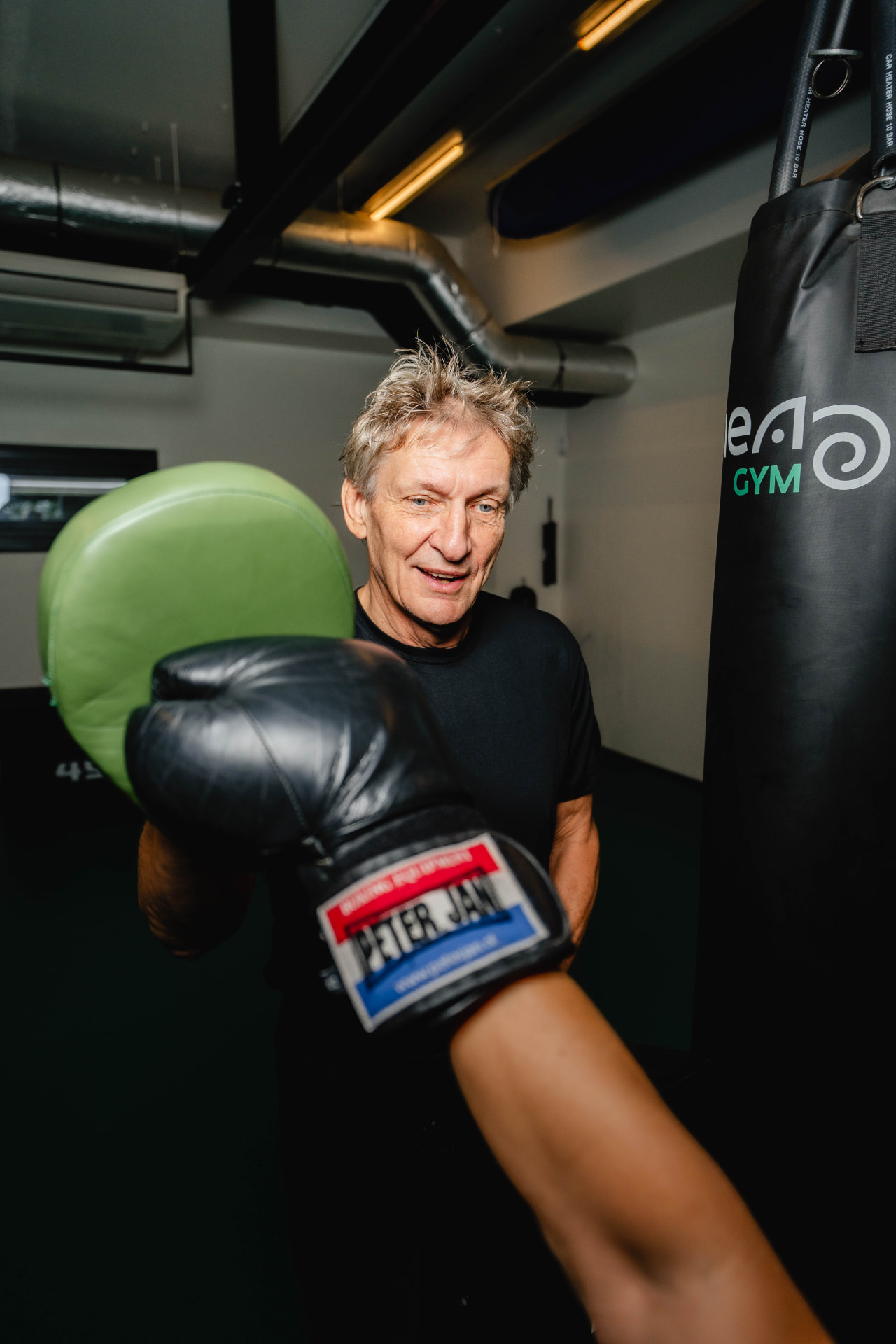 Twee sporters trainen samen met pads in de zaal van Mea Gym