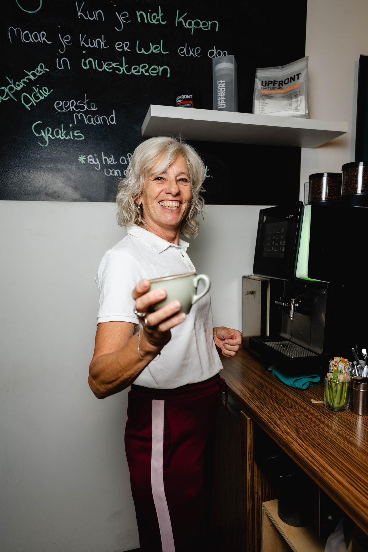 Medewerker achter de bar met een kop koffie