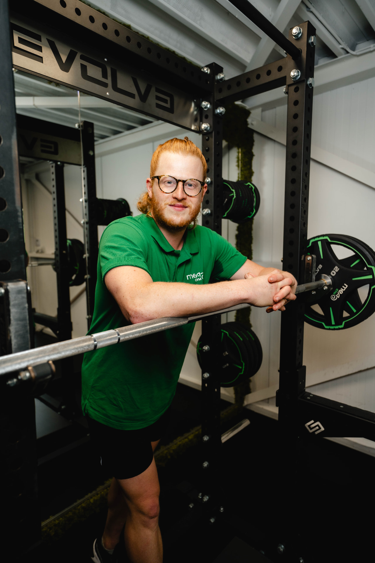 Trainer bij de squat rack in de outdoor container